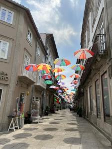 a row of colorful umbrellas hanging over a street at Viamar in Viana do Castelo