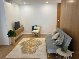 a living room with a blue couch and a chair at Viamar in Viana do Castelo