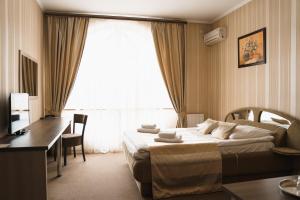 een hotelkamer met een bed en een bureau bij Globus Hotel in Ternopilʼ