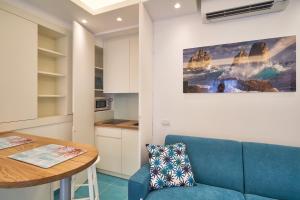 uma sala de estar com um sofá azul e uma mesa em ilTrucioloBBSuite em Anacapri