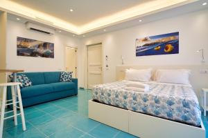 um quarto com uma cama e um sofá azul em ilTrucioloBBSuite em Anacapri