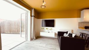 a living room with a couch and a tv at She's Electric in Blandford Forum