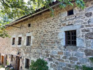 un vecchio edificio in pietra con una finestra sopra di Jasserie Les Airelles a Saint-Anthème