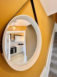 a round mirror on a wall in a hallway at She's Electric in Blandford Forum