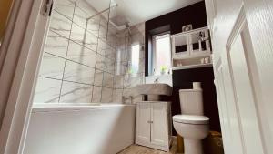 a bathroom with a tub and a toilet and a sink at She's Electric in Blandford Forum +14 photos