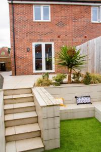 a garden with stairs in front of a brick building at She's Electric in Blandford Forum