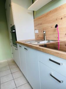 a kitchen with white cabinets and a sink at Traumschmiede in Rellingen