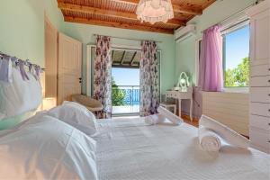 a bedroom with a bed and a desk and a window at Elies Villa Corfu in Áno Garoúna