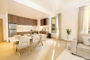 a kitchen and living room with a table and chairs at LUX The La Mer by The Sea Suite 4 in Dubai