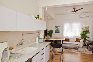 a kitchen with a sink and a living room at ^Superior 1 BR in the heart of the old north^ in Tel Aviv