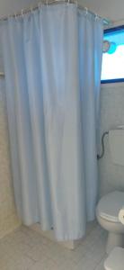a bathroom with a white shower curtain and a toilet at Cleo sweet room in Malia