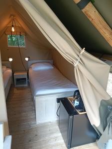 a bed in a tent in a room at Camping At Sea in Dronten