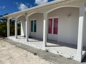 a white house with a porch and columns at ARCHE DE L'ISLE in Petit-Canal +3 photos