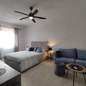 una camera con letto, divano e ventilatore a soffitto di Ratac a Pučišća