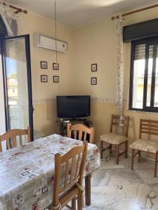 ein Esszimmer mit Tisch und Stühlen und einem Fernseher in der Unterkunft Geltrude in Avola