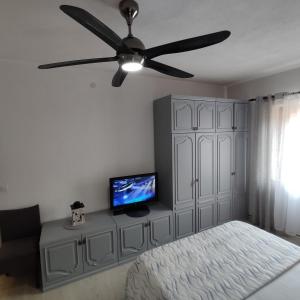 una camera da letto con ventilatore a soffitto e TV di Ratac a Pučišća