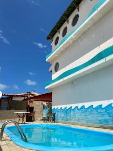 a swimming pool in front of a cruise ship at Pousada Acácias dos Corais in Cabo de Santo Agostinho