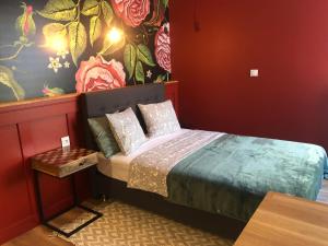 a bedroom with a bed and a wall with flowers at Rybaki 28 in Poznań