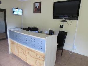 a reception desk in a room with a flat screen tv at Lalamnandzi1 in White River