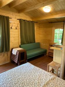 una camera con letto e panca in una cabina di AlbaVillage Hotel & Camping Wellness ad Alba