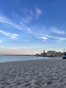 ein Sandstrand mit einer Stadt im Hintergrund in der Unterkunft Geltrude in Avola