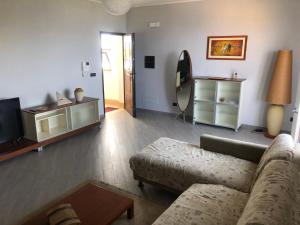 uma sala de estar com um sofá e uma televisão em Panta Rhei em Villa San Giovanni