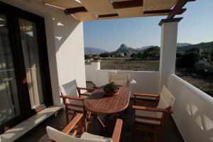 a wooden table and chairs on a balcony with a view at Markesi Apartments in Skiros