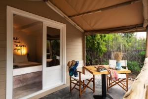 a patio with a table and chairs and a tent at Mwezi Boutique Resort in Jambiani
