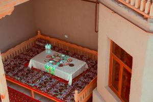 un tavolo con una tovaglia bianca in una stanza di Oqilanur Guest House a Khiva