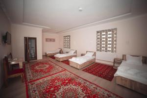 a living room with two couches and a rug at Oqilanur Guest House in Khiva