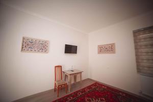 Televízia a/alebo spoločenská miestnosť v ubytovaní Oqilanur Guest House