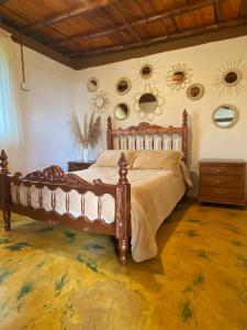 ein Schlafzimmer mit einem großen Holzbett in einem Zimmer in der Unterkunft La Casa Morada in Boquía