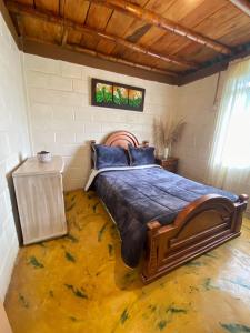 - une chambre avec un grand lit et un sol jaune dans l'établissement La Casa Morada, à Boquía
