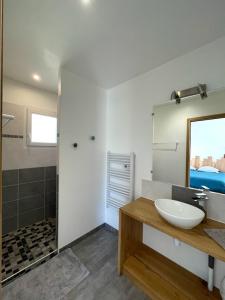 a white bathroom with a sink and a shower at La Bourdetaise in Le Bourdet