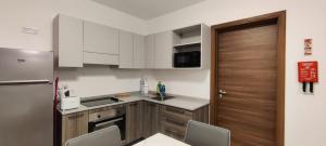 a kitchen with white cabinets and a wooden door at Blu-M Central in Qormi