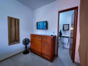 a room with a dresser with a television and a mirror at Aconchego na Chapada in Lençóis