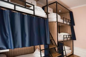 een kamer met een stapelbed en een blauw douchegordijn bij Rosalma Hostel in Porto