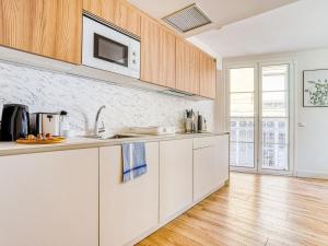 a kitchen with white cabinets and a hardwood floor at limehome Haro Calle de la Vega in Haro