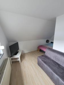 ein kleines Wohnzimmer mit einem Sofa und einem Bett in der Unterkunft Messezimmer am Thewissenweg in Düsseldorf