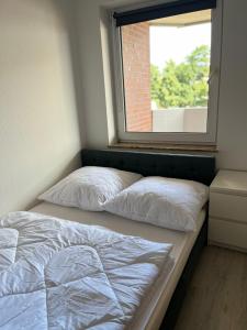 2 Betten in einem Zimmer mit Fenster in der Unterkunft Appartment 43 Haus Spiekeroog in Dornumersiel