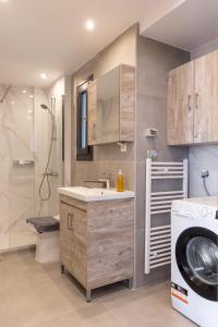 a bathroom with a sink and a washing machine at Anais Apartments in Korinós