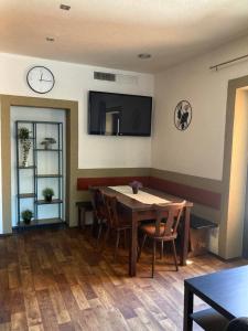una sala da pranzo con tavolo e orologio sul muro di Apartman U Mostu a Heraletz