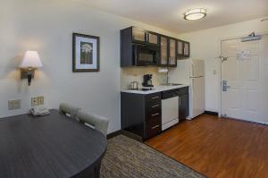 a small kitchen with a table and a dining room at Candlewood Suites Louisville Airport by IHG in Louisville