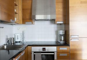 uma cozinha com um lavatório e um fogão forno superior em 2ndhomes Luxury 1BR Kamppi Center Apartment with Sauna and Big Terrace em Helsinque