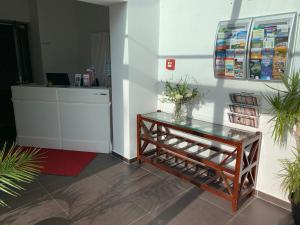プットブスにあるHotel & Steakhouse am Schlossparkの花の飾られたガラステーブルのあるロビー