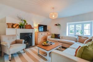 a living room with a couch and a fireplace at The Nook, Newly Available Relaxed 2 bed, Cotswolds in South Cerney