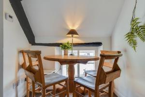 a dining room with a wooden table and chairs at The Nook, Newly Available Relaxed 2 bed, Cotswolds in South Cerney