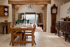 a dining room with a table and a grandfather clock at The Barn at Rigg End in Rosedale Abbey