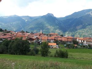 a town in a field with mountains in the background at Appartement confortable face à la montagne in Aime La Plagne