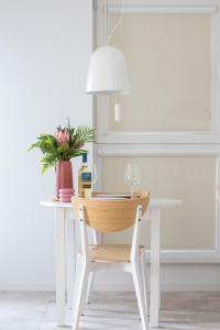 a white table with a wooden chair and a lamp at Apartment with Balcony & Parking Mogilska by Renters Prestige in Krakow